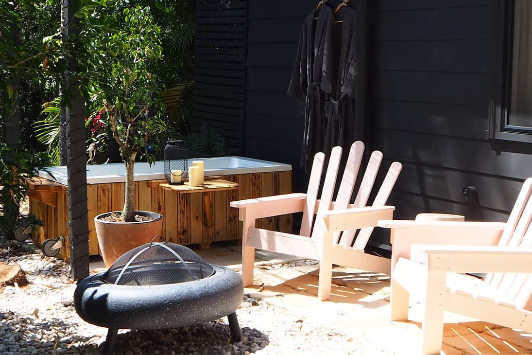 an outdoor bath and two garden chairs